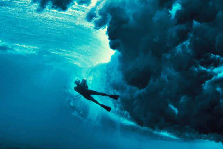 underwater photographer shoots underneath a wave